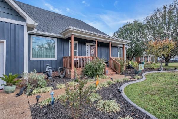 view of front of property featuring a porch, a shingled roof, and board and batten siding