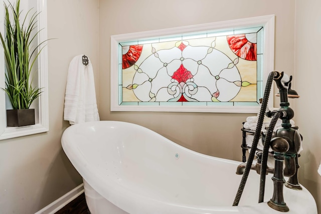 full bathroom featuring baseboards and a soaking tub