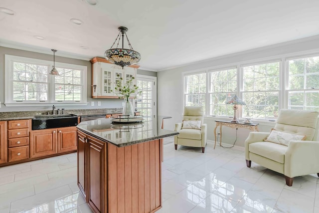 kitchen featuring a sink, dark stone counters, a healthy amount of sunlight, and open floor plan