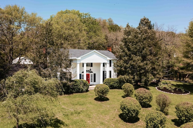 neoclassical / greek revival house featuring a chimney, french doors, and a front lawn