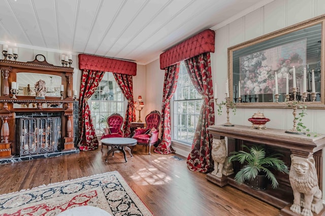 sitting room with visible vents, crown molding, and wood finished floors