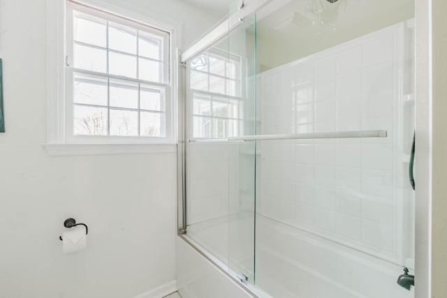 full bathroom featuring shower / bath combination with glass door and baseboards