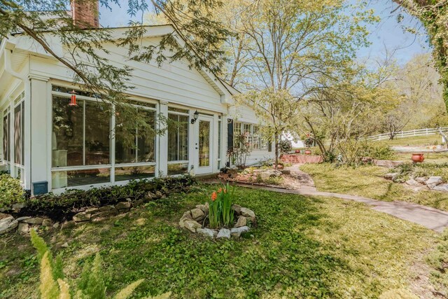 view of yard with a sunroom and fence