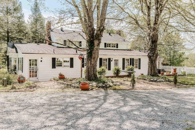 view of front of home featuring central AC, fence, and roof with shingles
