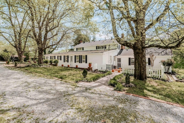 view of front of property featuring a chimney and fence private yard