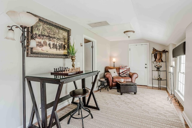 sitting room with vaulted ceiling, visible vents, and light wood-style floors
