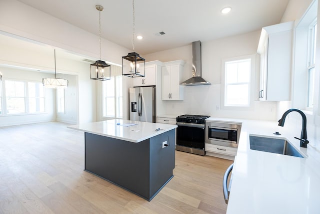4060 Penfield Dr Unit E, Franklin, TN 37069 - kitchen with wall chimney range hood, a kitchen island, appliances with stainless steel finishes, a sink, and light wood-style floors