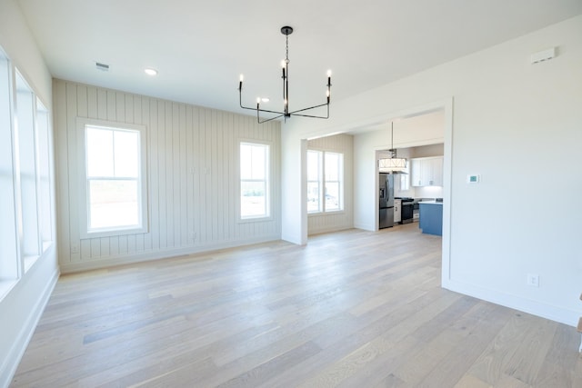 4060 Penfield Dr Unit E, Franklin, TN 37069 - unfurnished living room featuring light wood-style floors, a notable chandelier, and a wealth of natural light