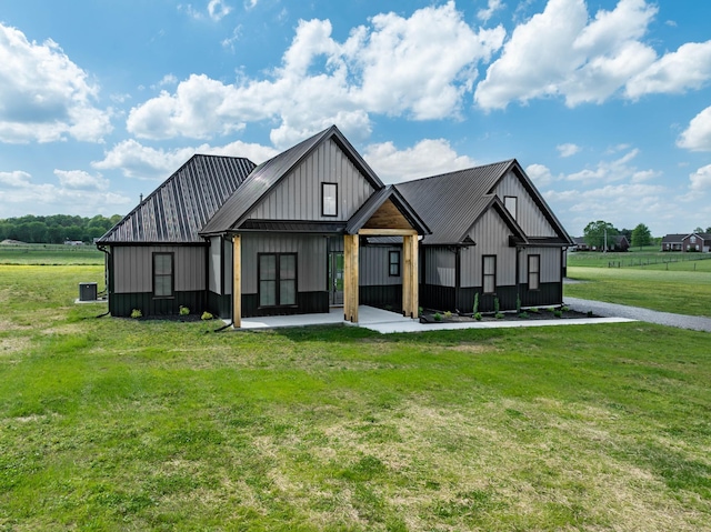 modern farmhouse style home with a patio, board and batten siding, a front lawn, and metal roof