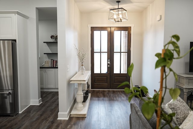 entrance foyer featuring a notable chandelier, dark wood-style floors, and french doors