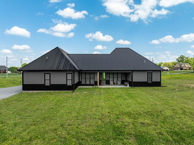 back of house with a lawn, metal roof, and a patio area