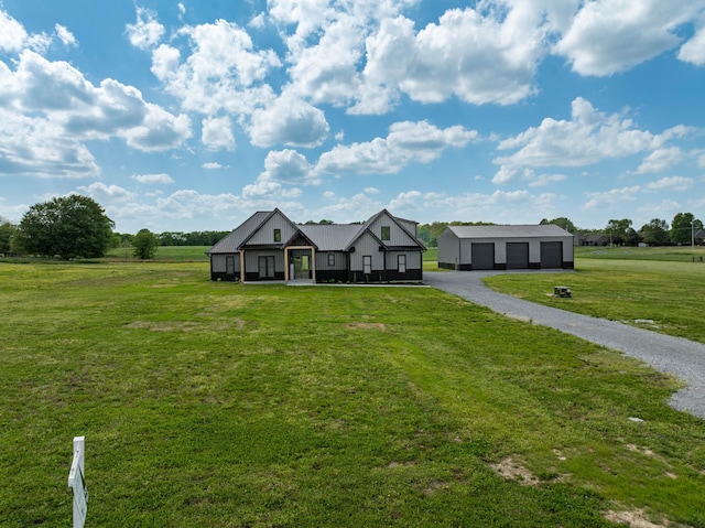 view of front facade featuring a garage, a front lawn, and an outbuilding