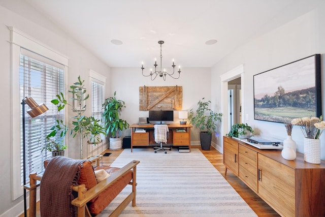 office area featuring baseboards, a chandelier, and wood finished floors