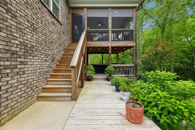 entrance to property featuring brick siding and a wooden deck
