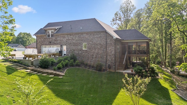back of house with a yard, brick siding, stairs, and a sunroom