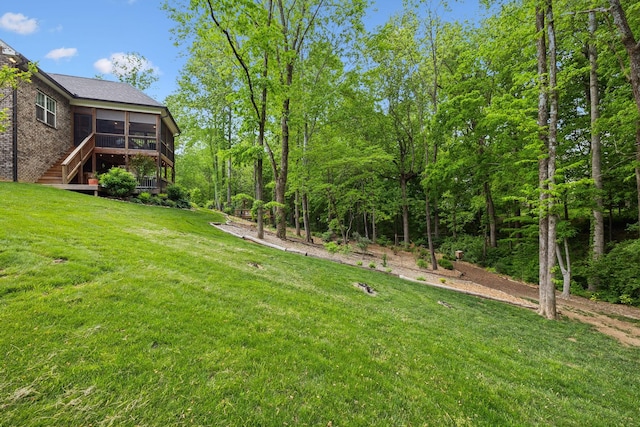 view of yard with a wooden deck, stairs, and a sunroom