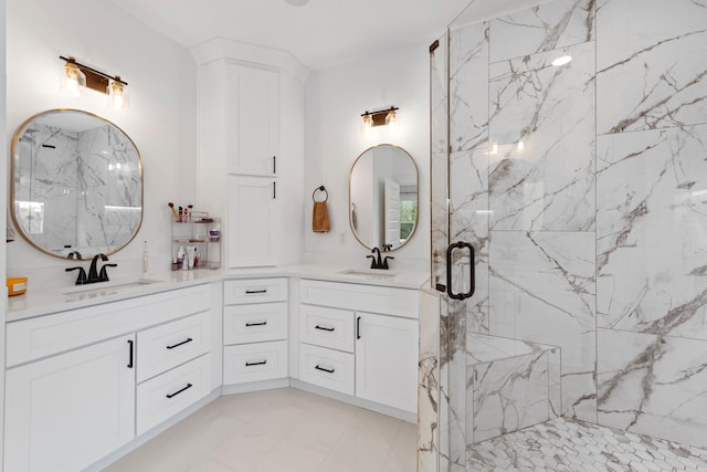 bathroom with double vanity, a sink, marble finish floor, and a marble finish shower