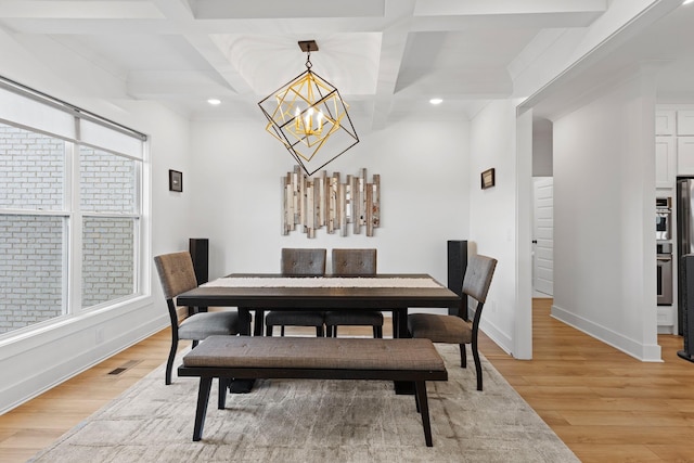 dining room with light wood-style floors, a notable chandelier, baseboards, and coffered ceiling