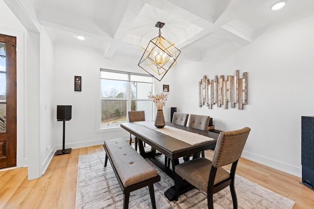 dining space featuring light wood-type flooring, coffered ceiling, baseboards, and a chandelier