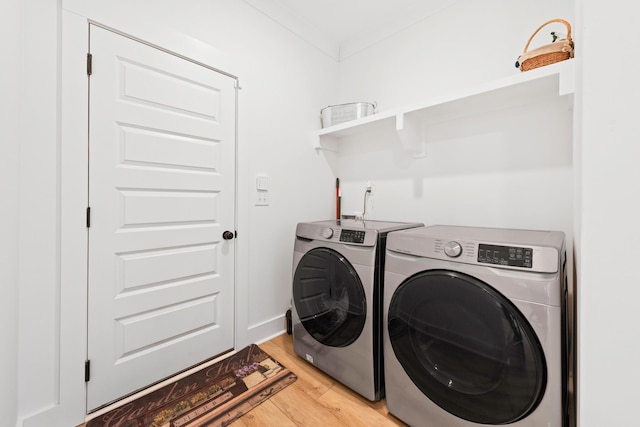 laundry room featuring light wood-style floors, laundry area, and washer and clothes dryer