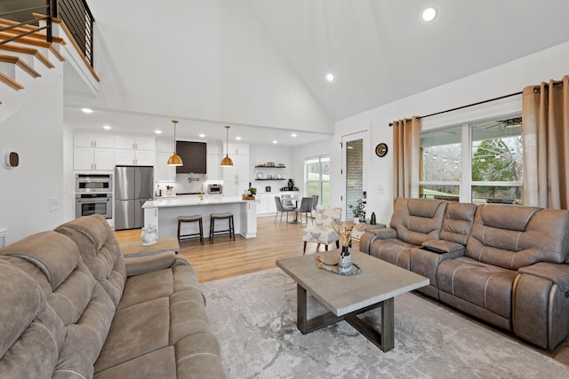 living room featuring light wood-style floors, recessed lighting, and high vaulted ceiling