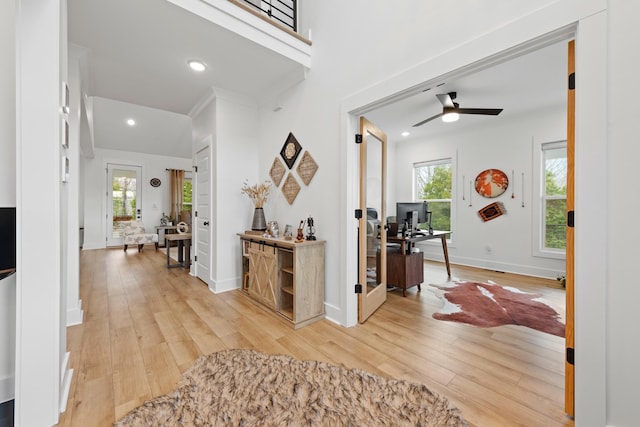 foyer entrance featuring light wood-style floors, ceiling fan, and a healthy amount of sunlight