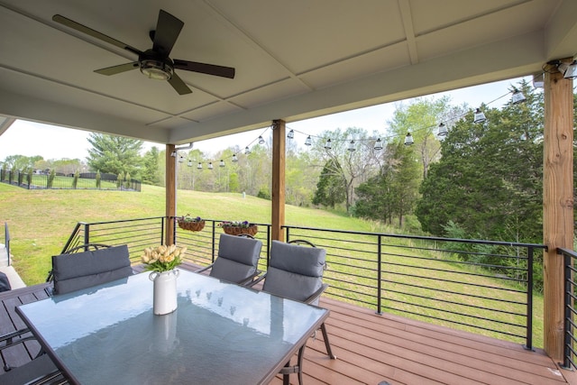 deck featuring a lawn, outdoor dining space, and ceiling fan