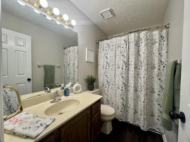 317 Village Ln W, Dickson, TN 37055 - bathroom with vanity, wood finished floors, curtained shower, toilet, and a textured ceiling