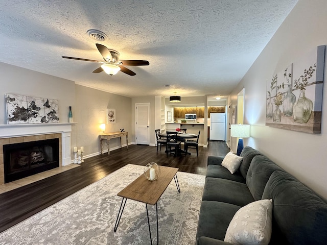 317 Village Ln W, Dickson, TN 37055 - living room featuring a ceiling fan, a textured ceiling, visible vents, baseboards, and dark wood-style floors