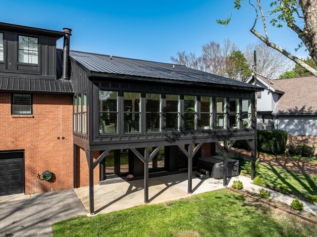 2025 Sanford Dr, Mount Juliet, TN 37122 - back of house with brick siding, a sunroom, a patio area, metal roof, and a lawn