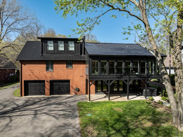 2025 Sanford Dr, Mount Juliet, TN 37122 - view of front of property featuring an attached garage, brick siding, a sunroom, driveway, and metal roof