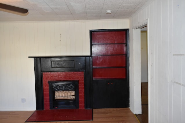 room details with wood walls, wood finished floors, and a fireplace