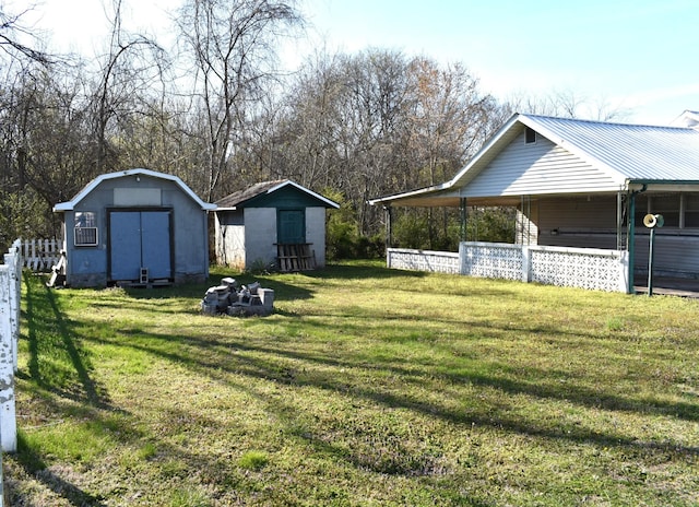 view of yard with an outdoor structure, a shed, and fence