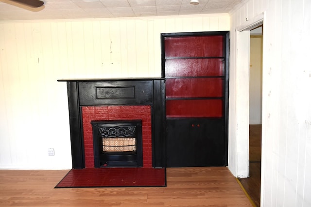 room details featuring wood walls, wood finished floors, and a fireplace