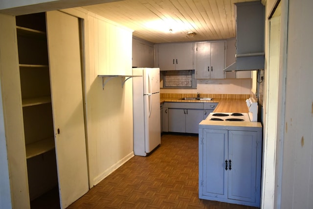 kitchen with a sink, wooden ceiling, gray cabinetry, freestanding refrigerator, and light countertops