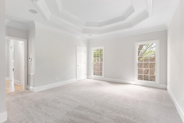 empty room with carpet floors, ornamental molding, baseboards, and visible vents