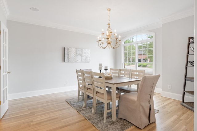 dining area with crown molding, baseboards, a chandelier, and light wood-type flooring