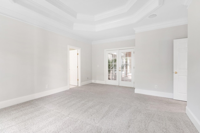 unfurnished room with french doors, ornamental molding, carpet, and a tray ceiling
