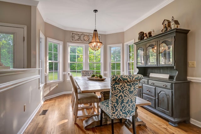 dining area with visible vents, crown molding, an inviting chandelier, baseboards, and light wood-style floors