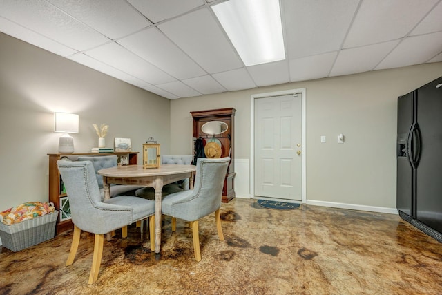 carpeted dining space with a drop ceiling