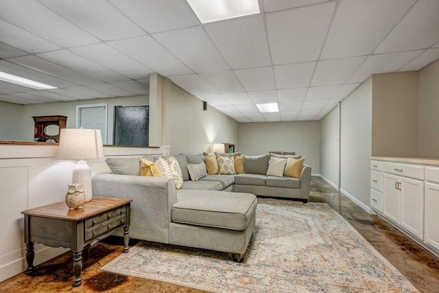 living room with baseboards and a drop ceiling