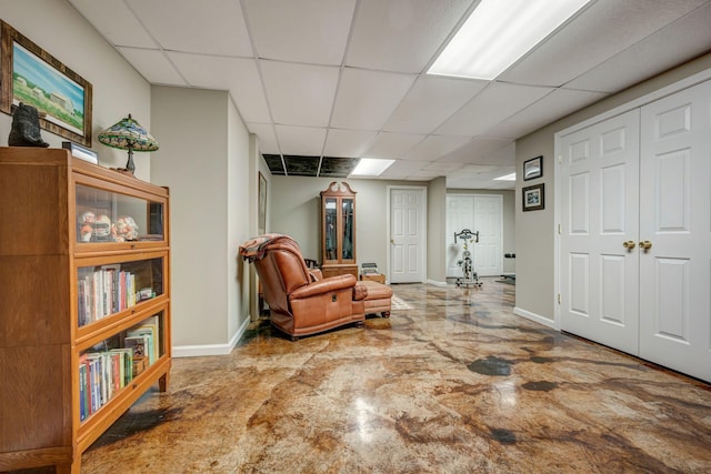 sitting room featuring baseboards and a paneled ceiling