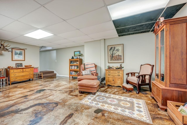 living area featuring stairs and a paneled ceiling
