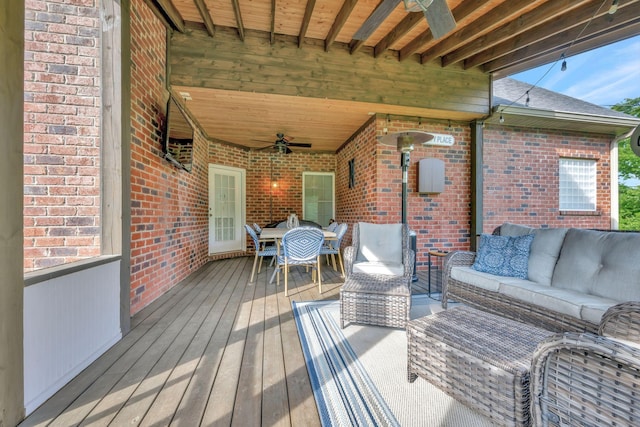 wooden deck featuring outdoor dining area, a ceiling fan, and an outdoor hangout area
