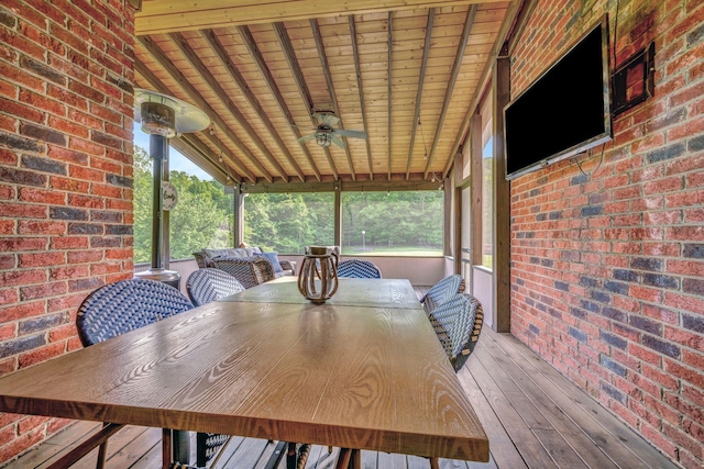 sunroom with ceiling fan and outdoor dining space