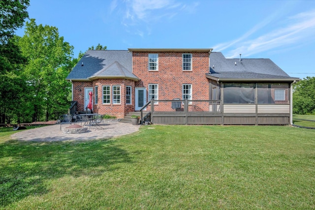 back of house with brick siding, a shingled roof, a patio area, and a lawn
