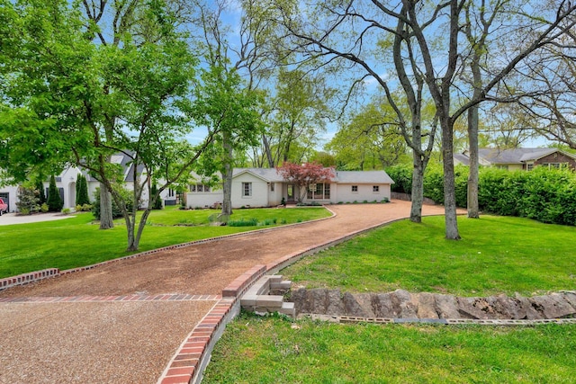 ranch-style home featuring driveway and a front yard