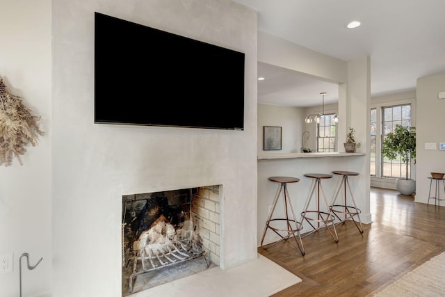 living room featuring recessed lighting, wood finished floors, and a fireplace