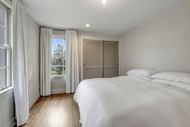 bedroom with recessed lighting, baseboards, a closet, and light wood-type flooring