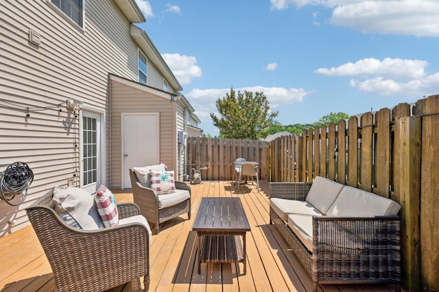 wooden deck featuring an outdoor hangout area and a fenced backyard